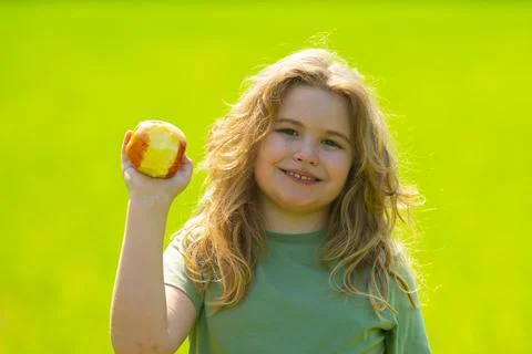The child boy eats an apple. Ripe fruit for kids. Child bites apple. The child Stock Photos
