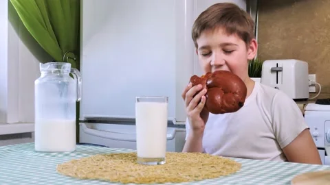 Child boy eats loaf of bread and drinks milk Stock Footage 135412721
