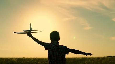 Child Boy flies into his future. Child boy runs with toy airplane on field, sun Stock Footage 241913431