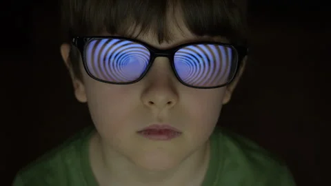 Child Boy With Glasses Watching Hypnotic Screen. Influence of Media on People Видео 274494422