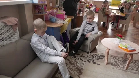 Child boy in kindergarten puts on soft shoes: Gomel, Belarus - May 2021 Stock Footage 178138287