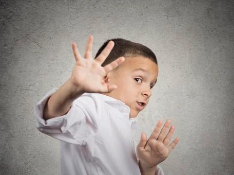 Child boy looking scared trying to protect himself Stock Photos