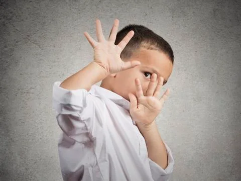 Child boy looking scared trying to protect himself Stock Photos