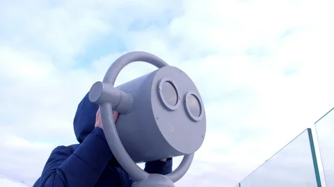 Child boy looks through binoculars in winter on overcast sky background. Video stock 117619617
