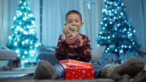 Child boy opens a box from Santa under the Christmas tree 스톡 동영상 257563452