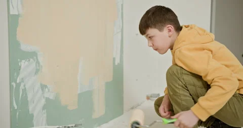 Child boy painted the wall with paint in the apartment. Children are home Stock Footage 273200492