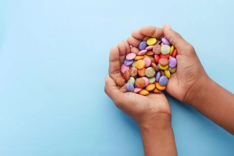 Child boy picking multi-colored sweet candies top view Stock Photos