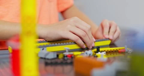 Child boy playing and building with colorful plastic bricks at the table Stock Footage 256406016