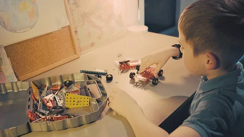 Child boy playing, builds, creating, metallic game toy in his children room Video stock 127755720