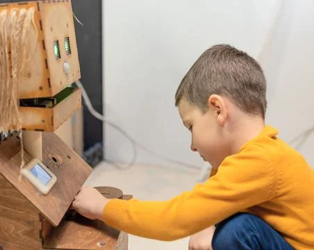 Child boy playing with cute robot. Concept of modern lifestyle and emerging Stock Photos