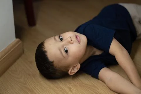 Child boy playing on the floor using a dark blue t-shirt Stock Photos