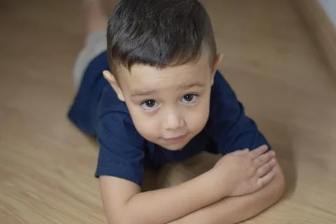 Child boy playing on the floor using a dark blue t-shirt Stock Photos
