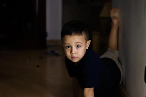 Child boy playing on the floor using a dark blue t-shirt Stock Photos