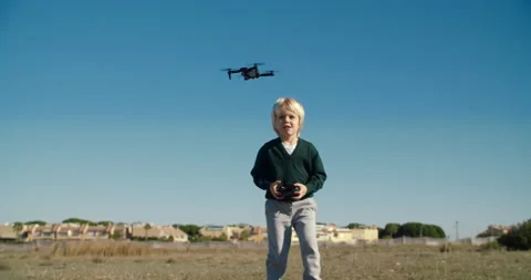 Child boy playing with mini toy drone outdoors using remote controller Stock Footage 168181558