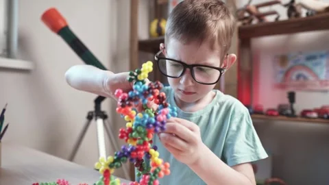 Child boy is playing with toy constructor for teaching the science of chemistry Stock Footage 277967900
