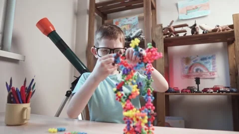 Child boy is playing with toy constructor for teaching the science of chemistry Stock Footage 277967936
