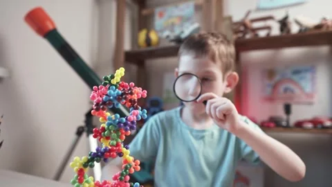 Child boy is playing with toy constructor for teaching the science of chemistry Stock Footage 277967956