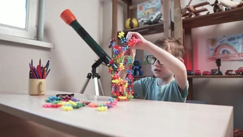 Child boy is playing with toy constructor for teaching the science of chemistry Stock Footage 277967986