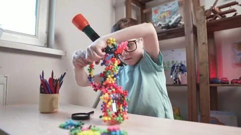 Child boy is playing with toy constructor for teaching the science of chemistry Stock Footage 277968024