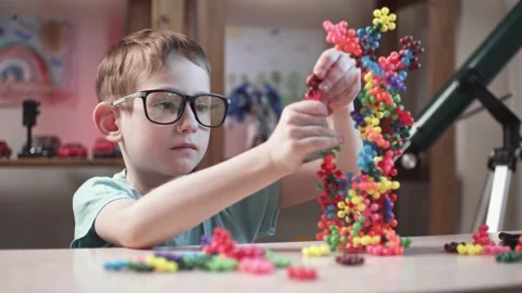 Child boy is playing with toy constructor for teaching the science of chemistry Stock Footage 277968067
