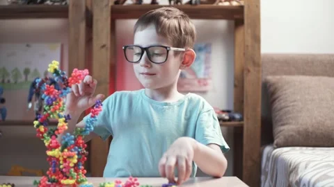 Child boy is playing with toy constructor for teaching the science of chemistry Stock Footage 277968092