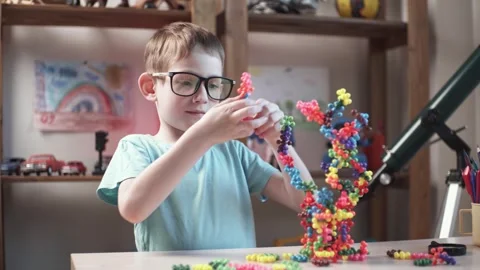 Child boy is playing with toy constructor for teaching the science of chemistry Stock Footage 277968121