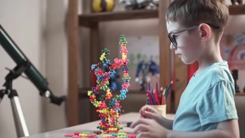 Child boy is playing with toy constructor for teaching the science of chemistry Stock Footage 277968141