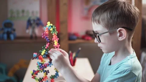 Child boy is playing with toy constructor for teaching the science of chemistry Stock Footage 277968188