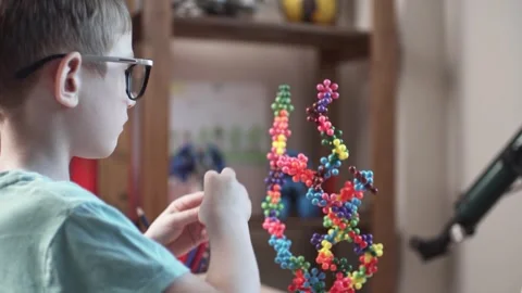 Child boy is playing with toy constructor for teaching the science of chemistry Stock Footage 277968189