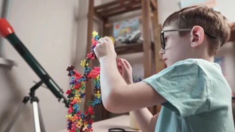 Child boy is playing with toy constructor for teaching the science of chemistry Stock Footage 277968213