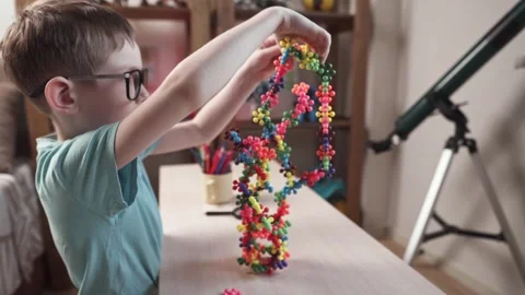 Child boy is playing with toy constructor for teaching the science of chemistry Stock Footage 277968227