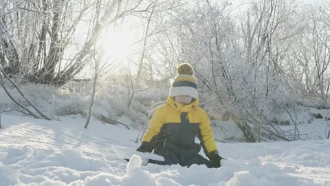 A child boy plays in winter throwing snow on a sunny frosty day Stock Footage 294347551