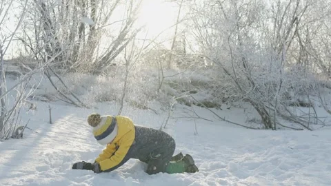 A child boy plays in winter throwing snow on a sunny frosty day Stock Footage 294347854