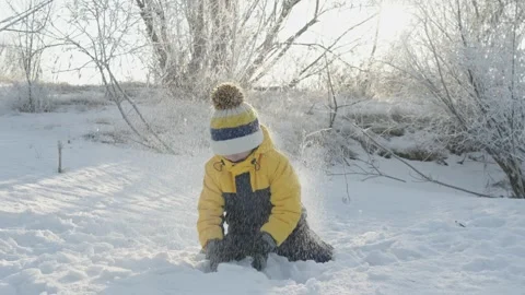 A child boy plays in winter throwing snow on a sunny frosty day Stock Footage 294347921