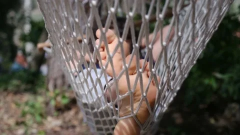 Child boy is resting in hammock in garden, in sunny summer day. Stock Footage 238367562