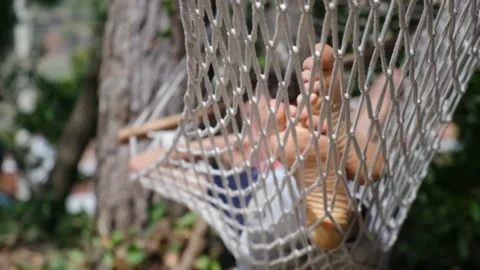 Child boy is resting in hammock in garden, in sunny summer day. Stock Footage 238367705