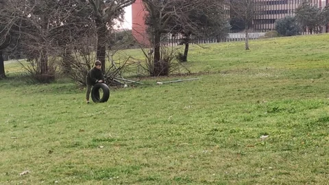 Child boy running auto car tire wheel. Young kid playing in rural countryside Stock Footage 238371004