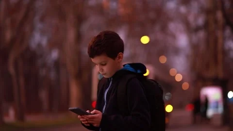 Child boy of school age flies along the road with a phone, use of phones Stock Footage 234223715
