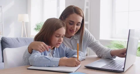 Child boy studying online class with mother on laptop during remote lesson Stock Footage 317355653