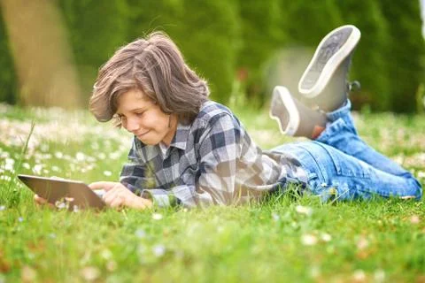 Child Boy using digital tablet in park Stock Photos