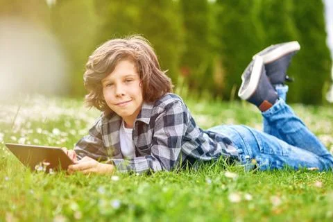 Child Boy using digital tablet in park Stock Photos