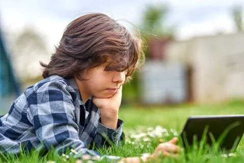 Child Boy using digital tablet in park Stock Photos