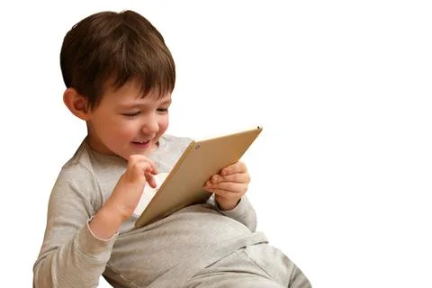 Child boy using digital tablet for entertainment. Happy kid touching screen o Stockfoto's