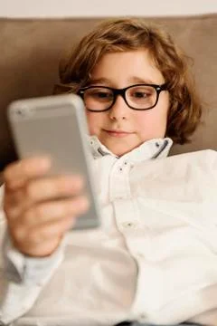 Child boy using his mobile phone. Stock Photos