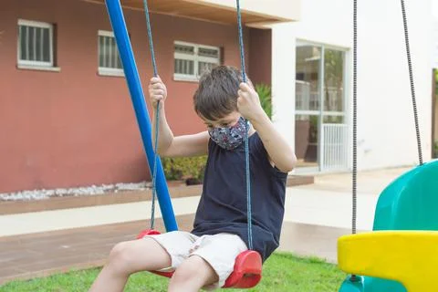 Child boy using a mask playing and swing in a playground 스톡 사진