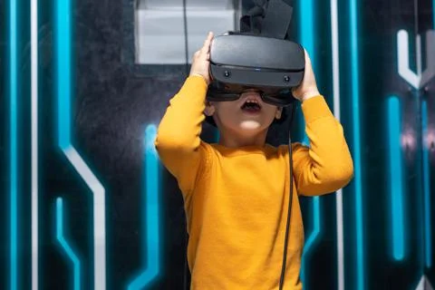 Child boy using virtual or augmented reality glasses. Concept of modern Stock Photos