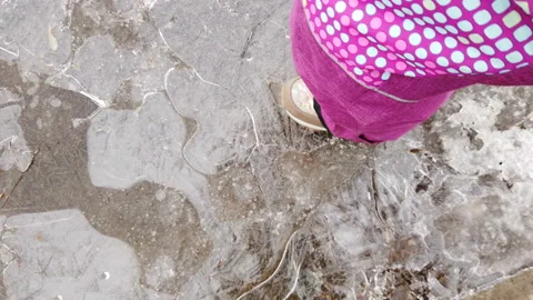 A child breaks an ice puddle. Stock Footage 151503880
