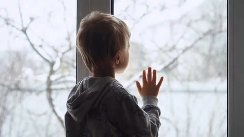 Child breathes on the window to be able to draw with finger on the window glass Video stock 100304075