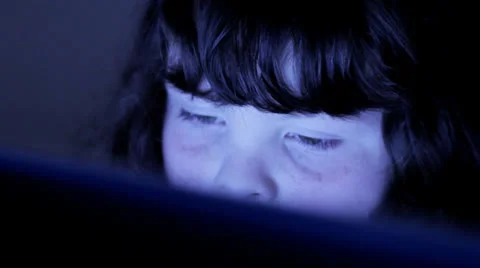 Child browsing interent, face lit by computer screen Stockbeeldmateriaal 22498239