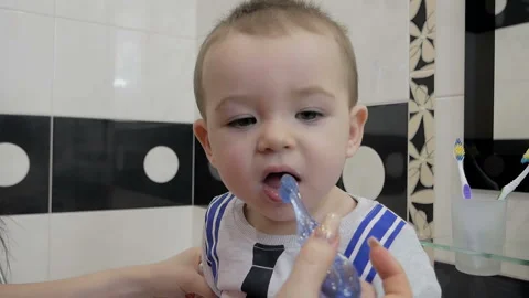A child is brushing his teeth in front of a mirror. Stock Footage 125077079